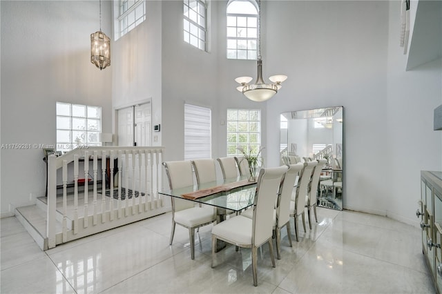 dining area with a healthy amount of sunlight, a high ceiling, and baseboards