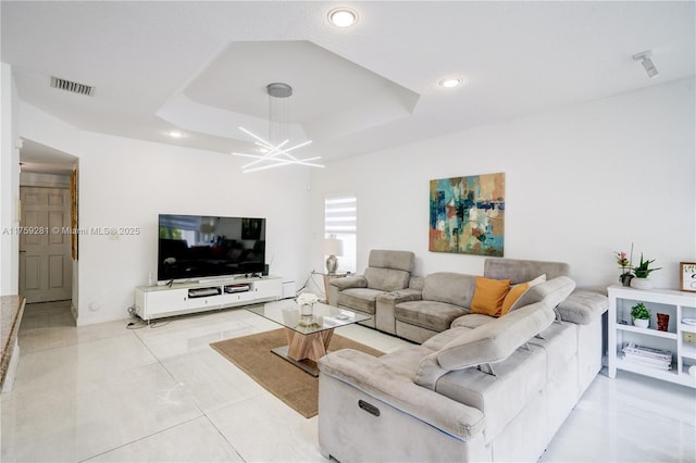 living room with light tile patterned floors, recessed lighting, a notable chandelier, visible vents, and a tray ceiling