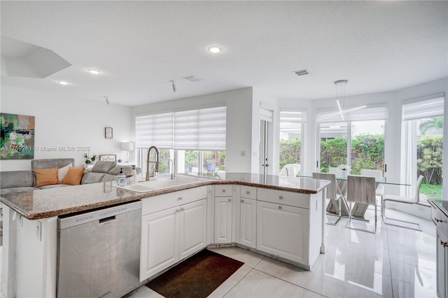 kitchen with a sink, visible vents, white cabinetry, open floor plan, and stainless steel dishwasher