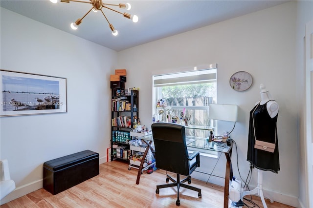 home office featuring a notable chandelier, baseboards, and wood finished floors