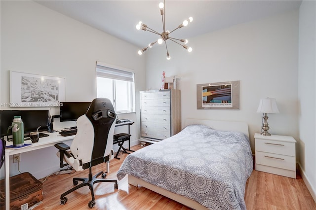 bedroom with a chandelier, wood finished floors, and baseboards