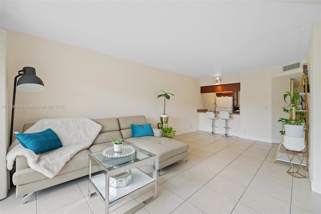 tiled living room featuring baseboards and visible vents