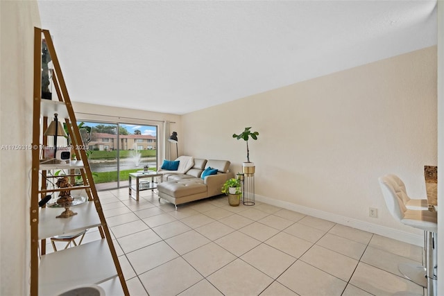 living area with light tile patterned floors and baseboards