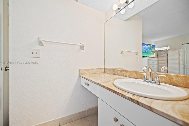 bathroom with tile patterned flooring, vanity, and baseboards