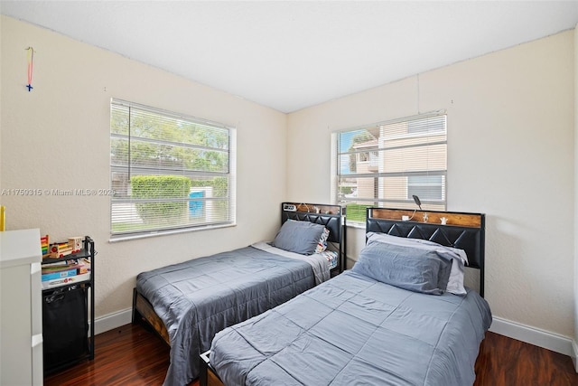 bedroom with baseboards and wood finished floors