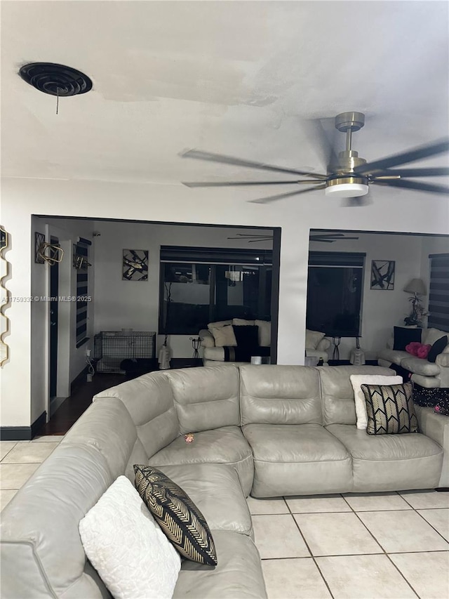 living area featuring tile patterned flooring and ceiling fan