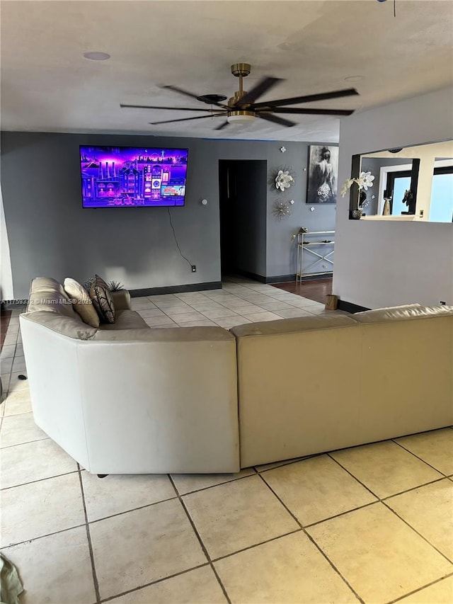 unfurnished living room with tile patterned floors, baseboards, and a ceiling fan