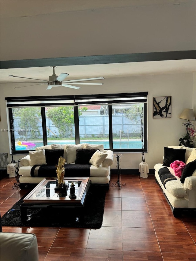 living room with baseboards, plenty of natural light, and a ceiling fan