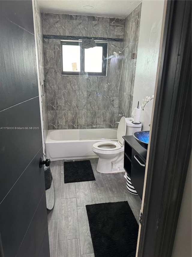 full bath featuring toilet, vanity, bathtub / shower combination, and wood tiled floor