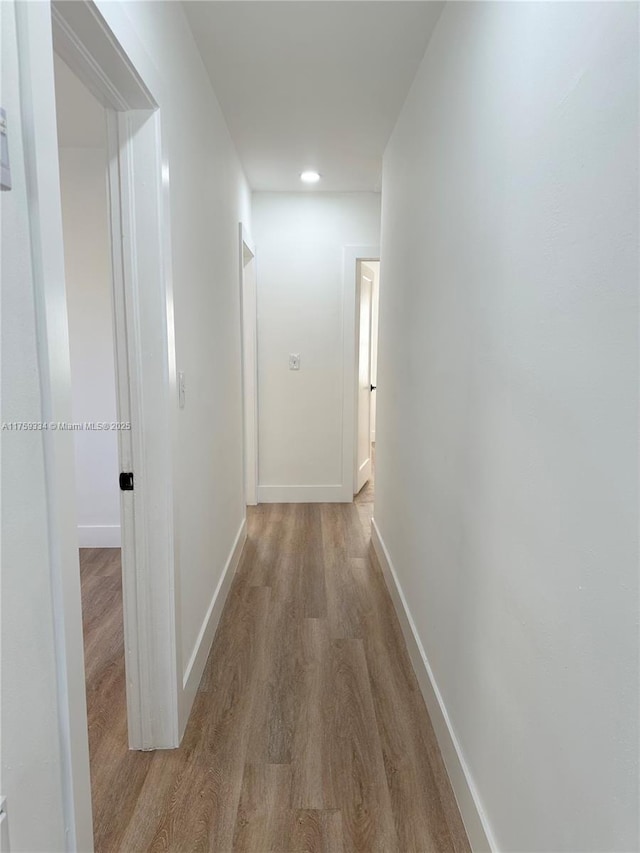 hall with wood finished floors and baseboards