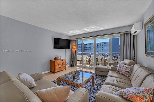 living room featuring tile patterned flooring, a textured ceiling, baseboards, and a wall unit AC