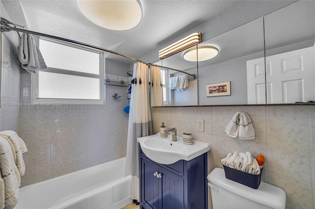 full bathroom with toilet, shower / tub combo with curtain, a textured ceiling, tile walls, and vanity