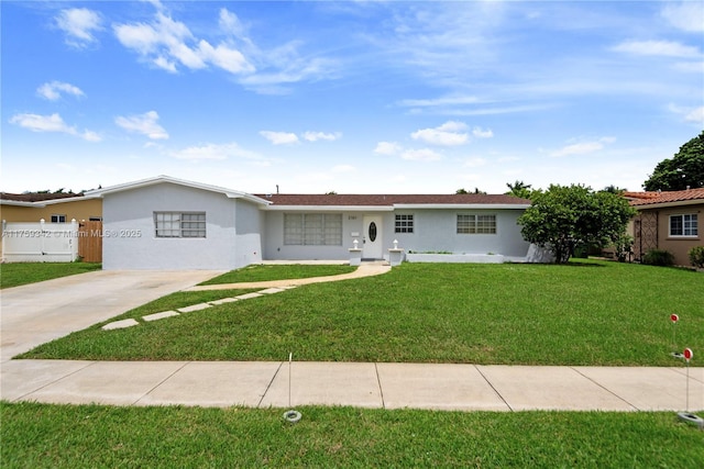 ranch-style house featuring a front yard, stucco siding, fence, and concrete driveway