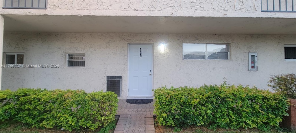 entrance to property featuring stucco siding