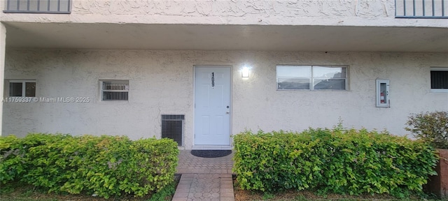 entrance to property featuring stucco siding