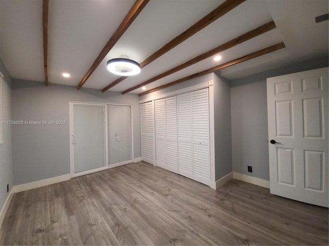 below grade area featuring recessed lighting, wood finished floors, and baseboards