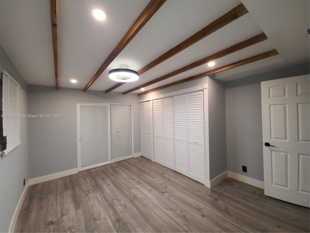 basement featuring baseboards, wood finished floors, and recessed lighting