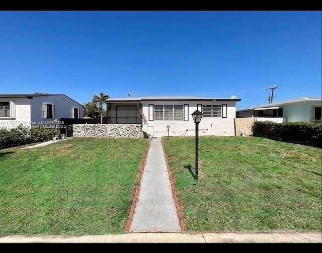 view of front of house with a sunroom, a front yard, and fence