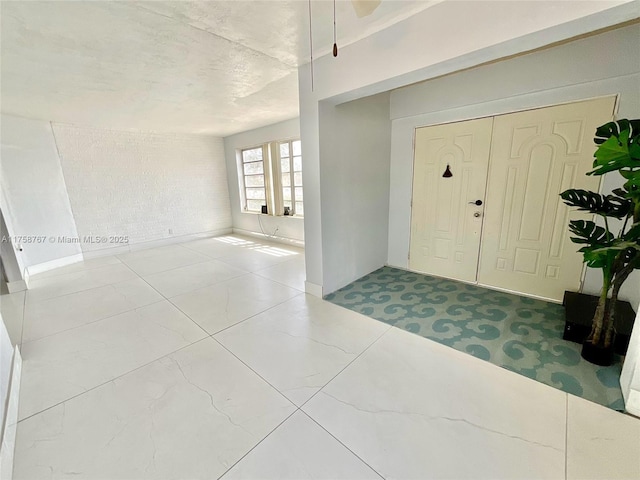 foyer entrance featuring brick wall