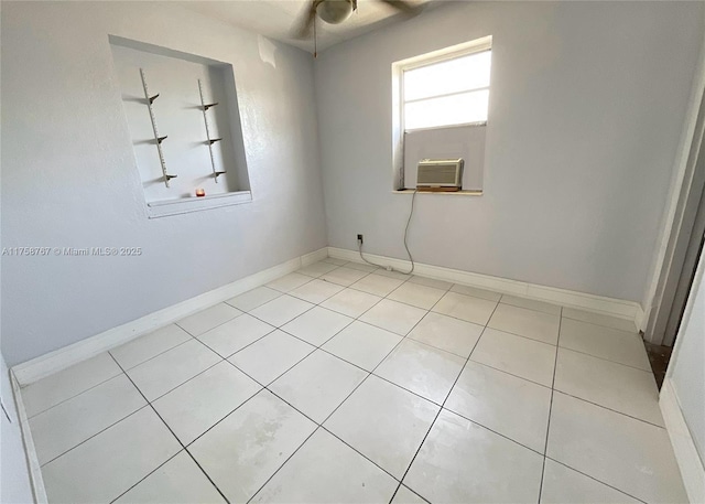 spare room featuring cooling unit, baseboards, and light tile patterned floors