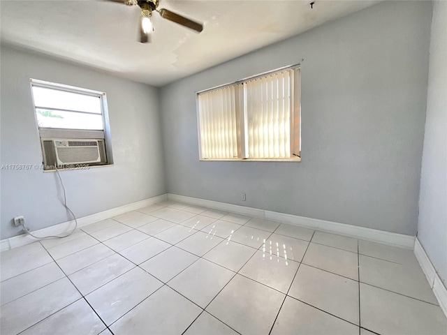 empty room featuring light tile patterned floors, cooling unit, a ceiling fan, and baseboards