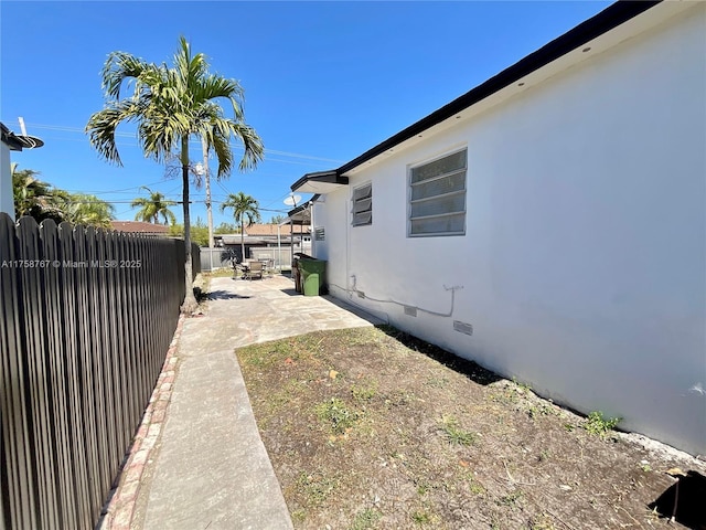 view of home's exterior with a patio area, crawl space, a fenced backyard, and stucco siding