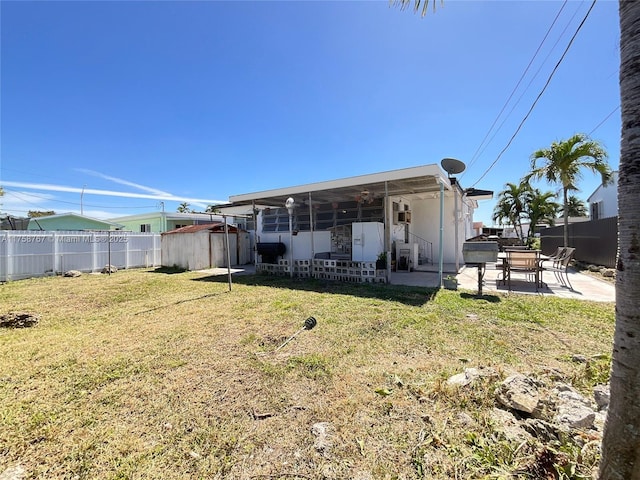 back of property with a lawn, a patio area, a shed, fence private yard, and an outdoor structure