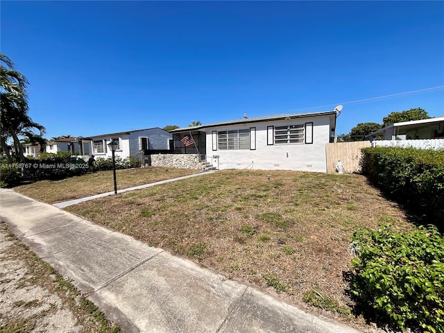 view of front of property with a front yard and fence