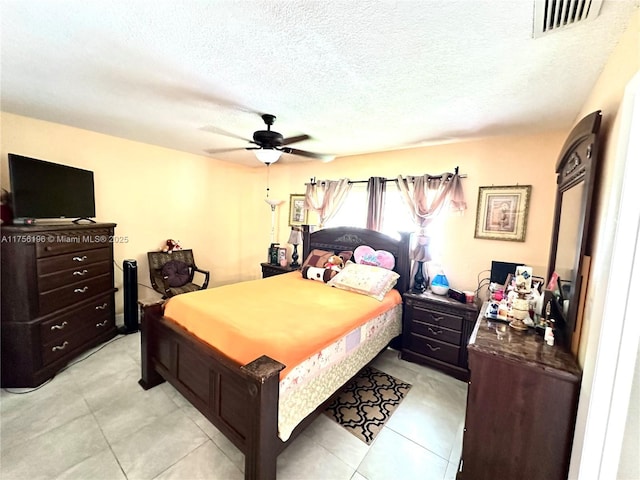 bedroom with a textured ceiling, visible vents, and a ceiling fan