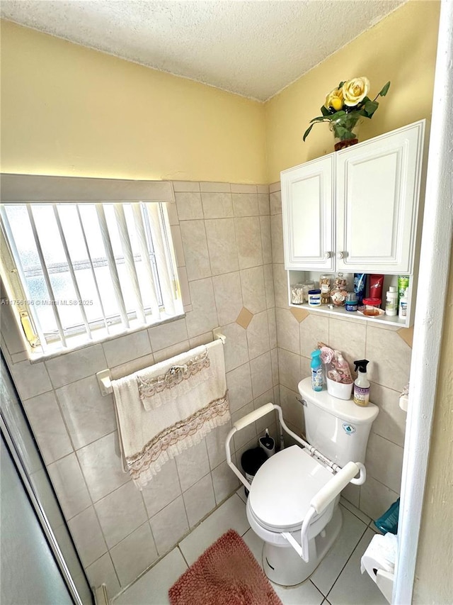 bathroom featuring toilet, tile walls, a textured ceiling, and tile patterned floors