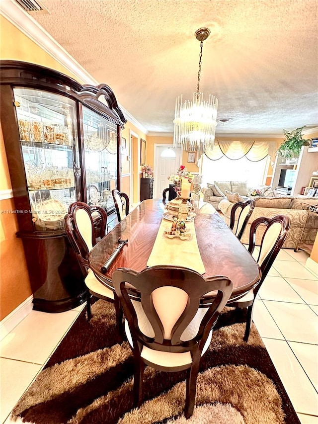 dining room with a textured ceiling, a healthy amount of sunlight, tile patterned floors, and crown molding