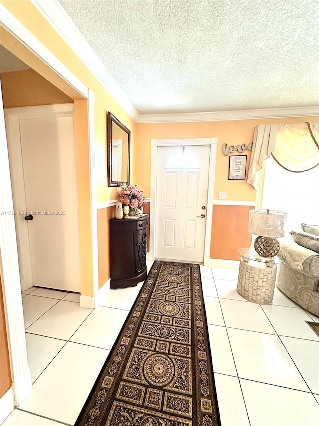 interior space featuring a textured ceiling, light tile patterned flooring, and crown molding