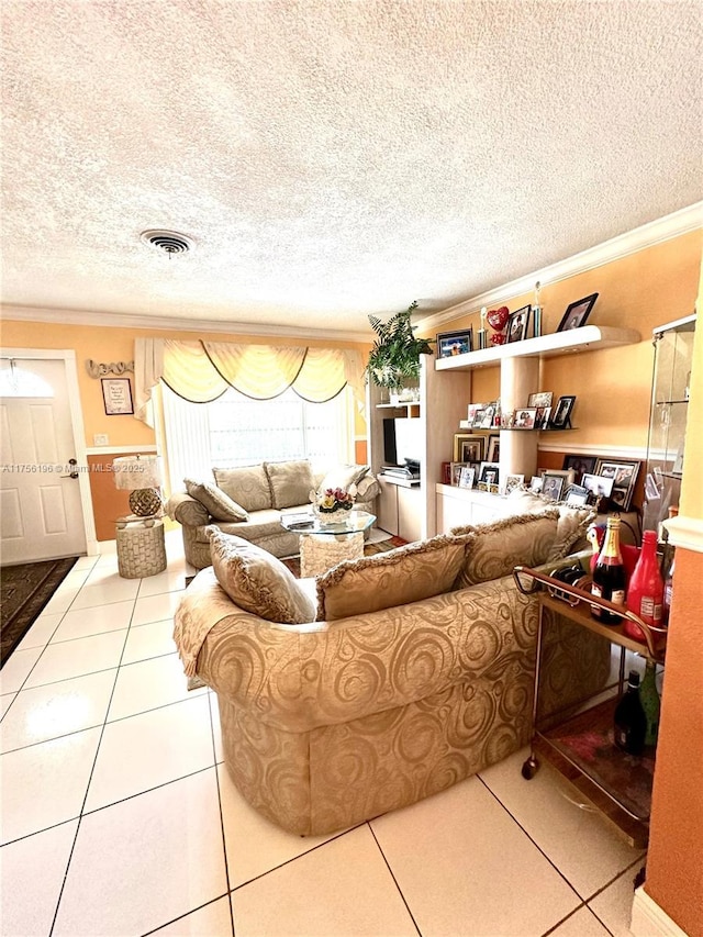 living area with visible vents, ornamental molding, a textured ceiling, and tile patterned floors