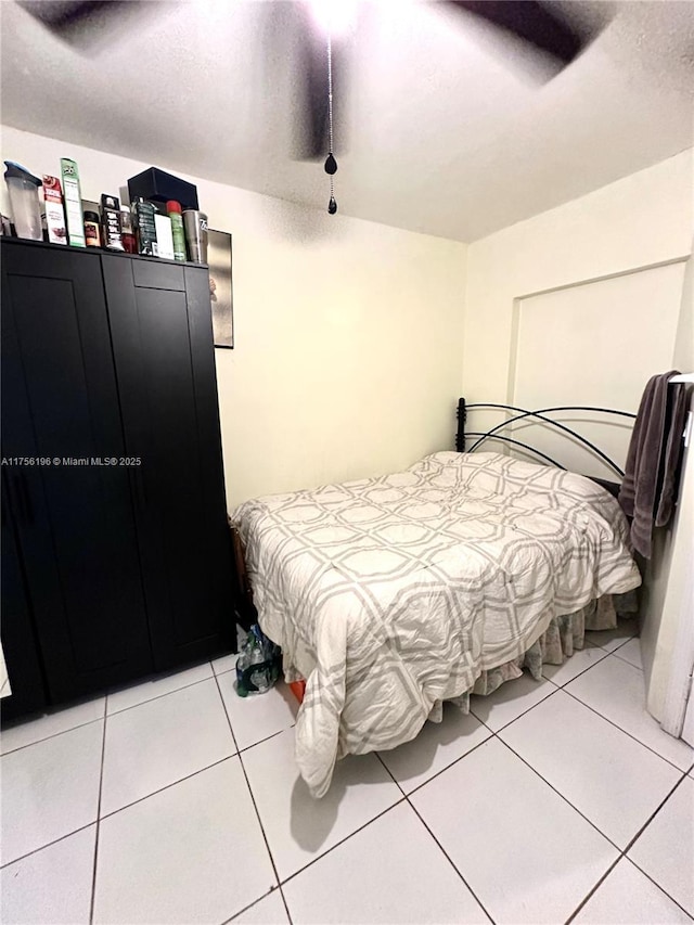 bedroom featuring ceiling fan, a textured ceiling, and light tile patterned floors