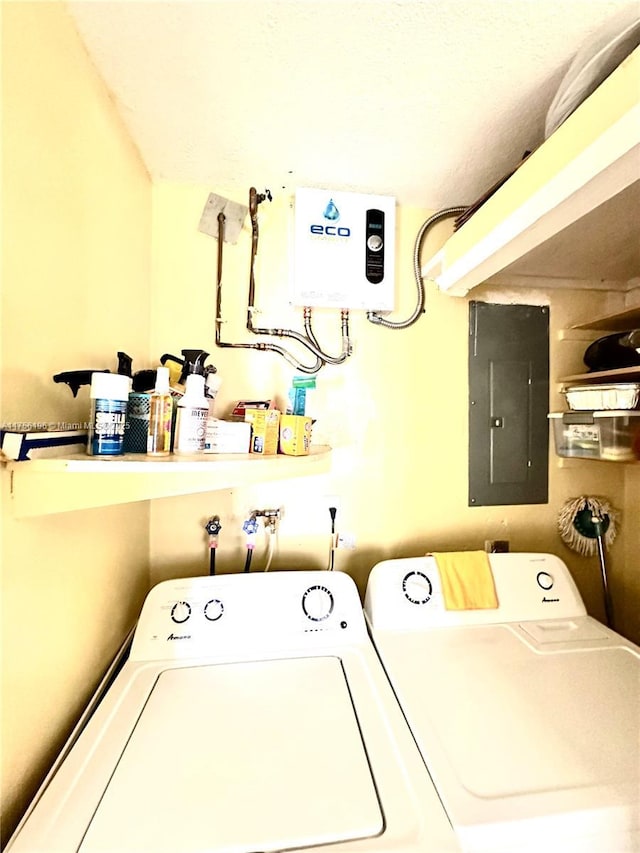 washroom featuring water heater, laundry area, electric panel, and washer and clothes dryer