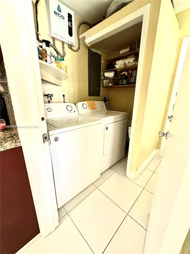 laundry room featuring washing machine and dryer, laundry area, electric panel, and light tile patterned floors