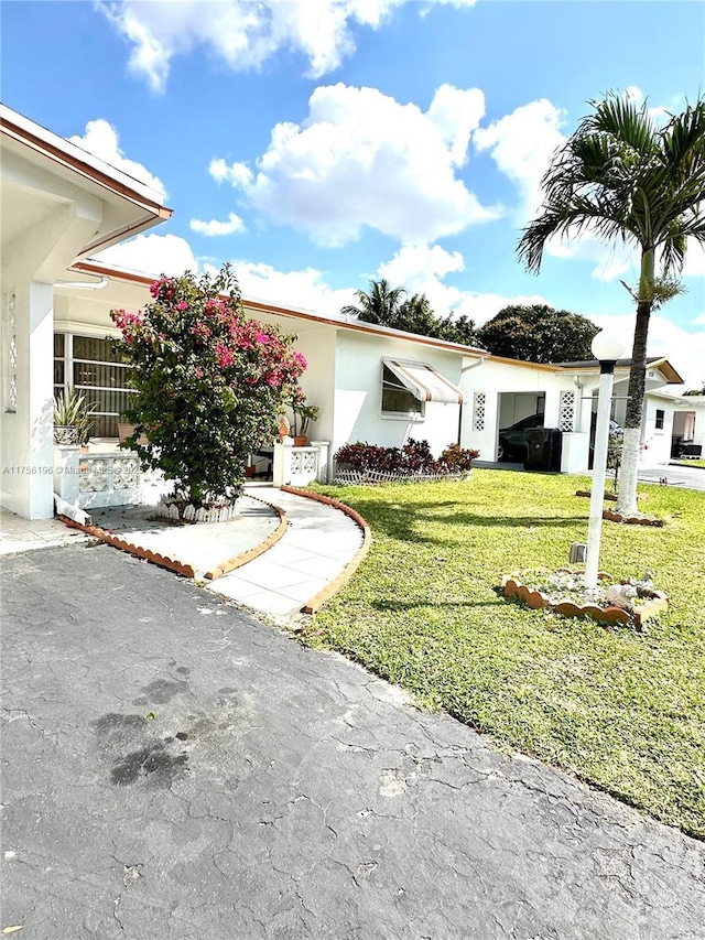 view of front facade with a front lawn and stucco siding