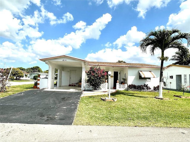 view of front of house featuring aphalt driveway, a carport, a front lawn, and stucco siding