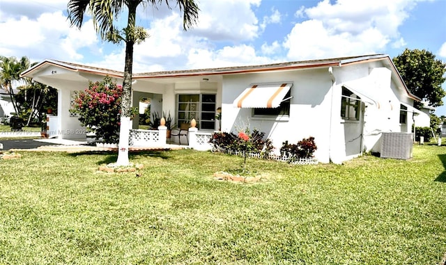 ranch-style home featuring central AC, a front yard, and stucco siding