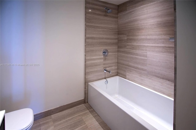 full bath featuring toilet, shower / bath combination, and baseboards