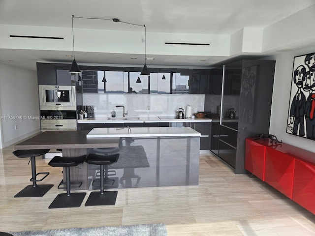 1451 Brickell Ave Unit 1201, Miami, FL 33131 - kitchen featuring modern cabinets, a center island, dark cabinets, and a kitchen breakfast bar