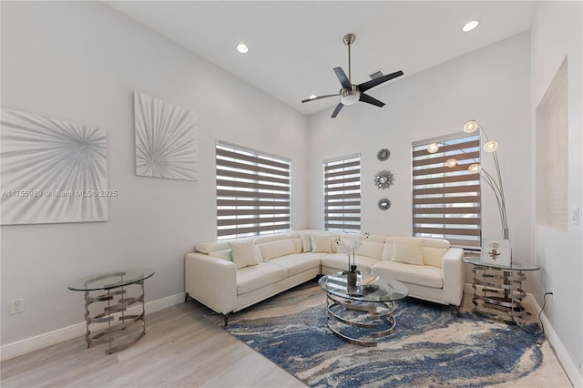 living area with a ceiling fan, recessed lighting, wood finished floors, and baseboards