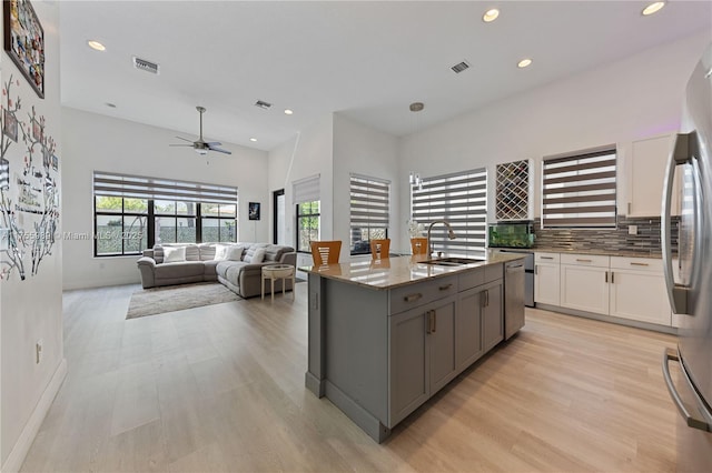 kitchen with light stone counters, visible vents, appliances with stainless steel finishes, and a sink