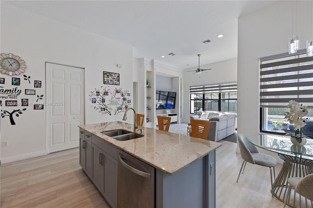 kitchen featuring visible vents, gray cabinetry, a sink, light wood-style floors, and dishwasher