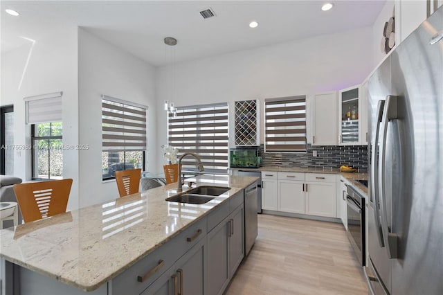 kitchen featuring visible vents, a sink, backsplash, appliances with stainless steel finishes, and white cabinets