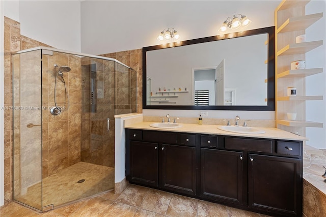 bathroom featuring a shower stall, double vanity, and a sink