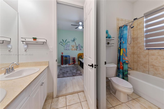 bathroom featuring tile patterned floors, toilet, double vanity, and a sink