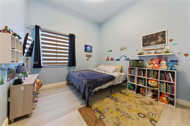 bedroom with baseboards and wood finished floors