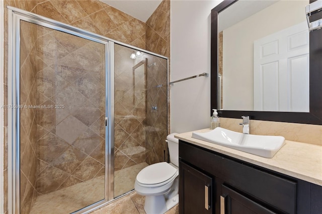 bathroom featuring toilet, a stall shower, and vanity