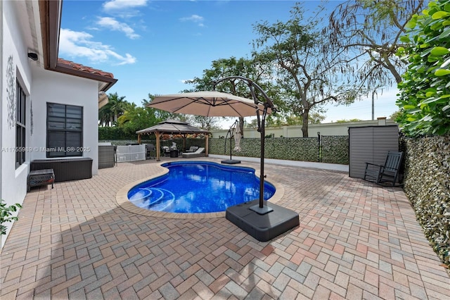 view of pool featuring fence, a fenced in pool, a gazebo, an outdoor structure, and a patio area